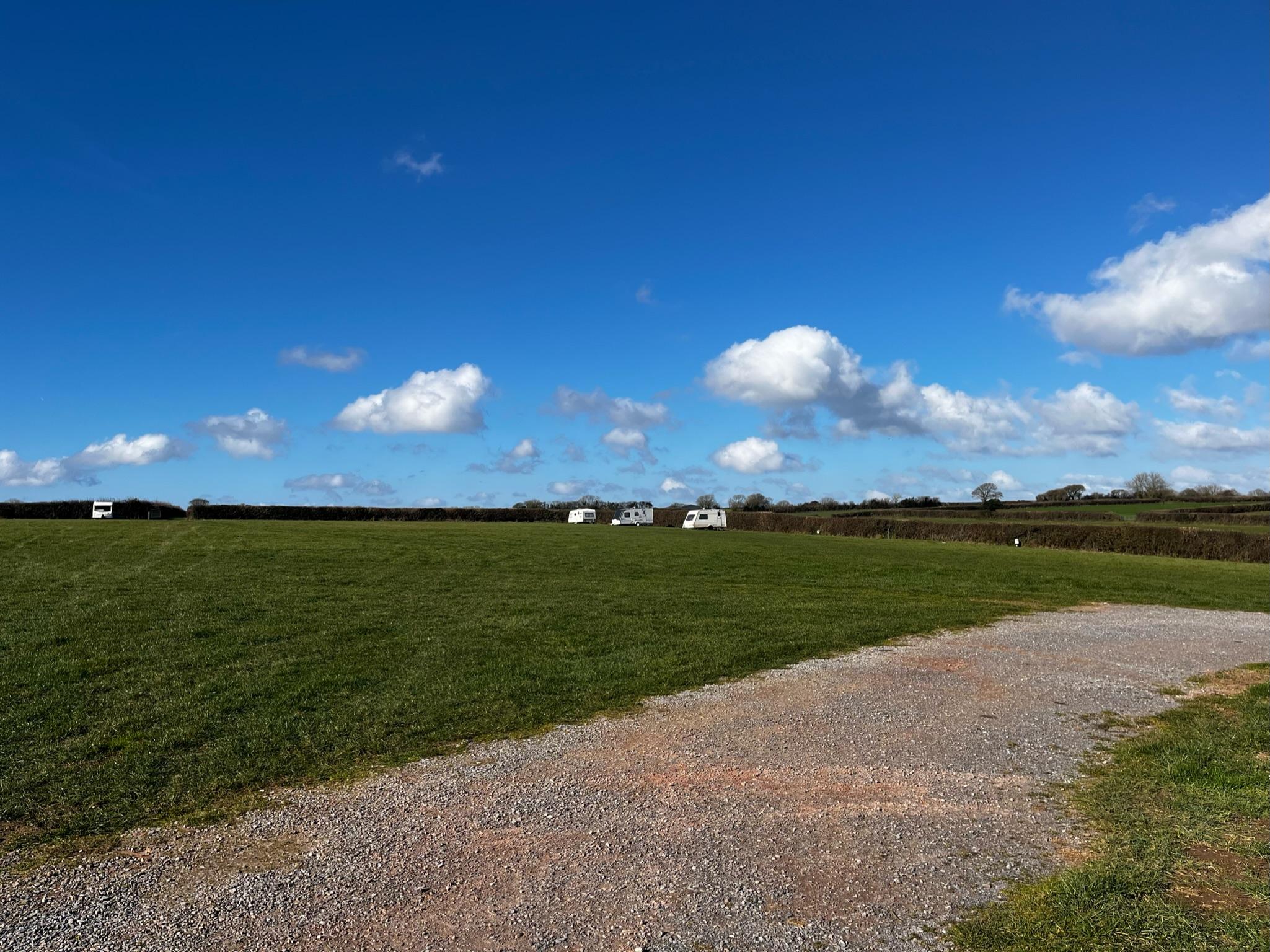 Wide shot of a camping field with a few mobile caravans pitched up