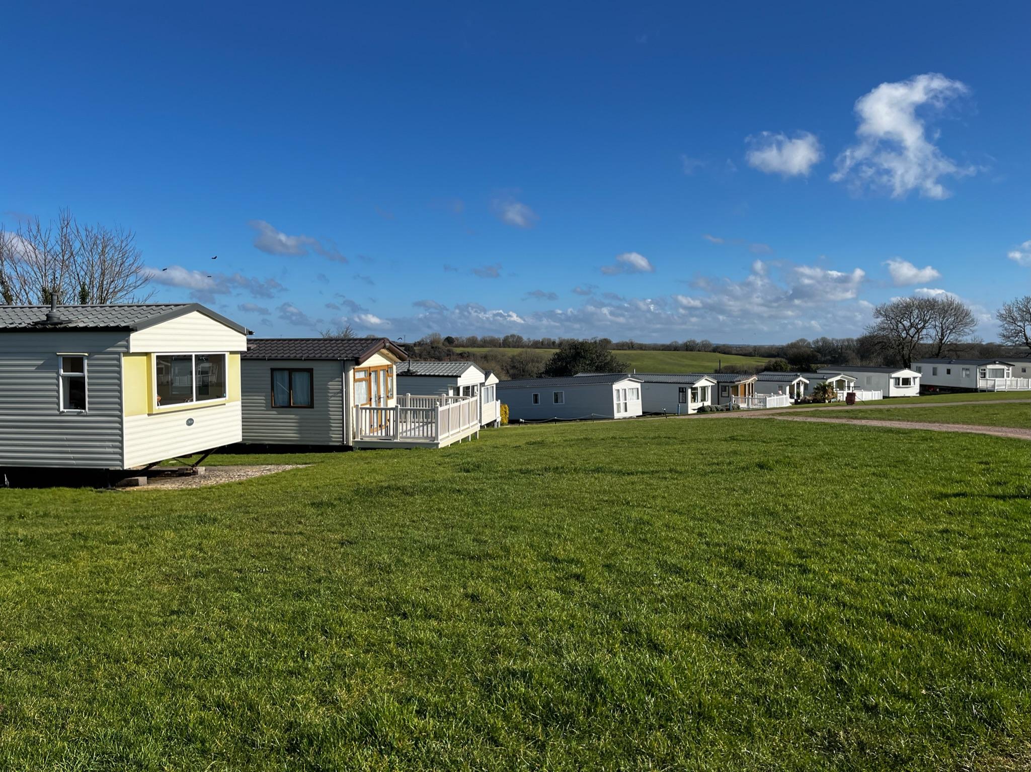 Side view of caravans around the outside of a large field